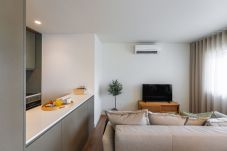 Modern living room with sofa, smart TV, and access to the balcony
