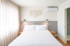 Habitación moderna con cama, armario y luz natural.